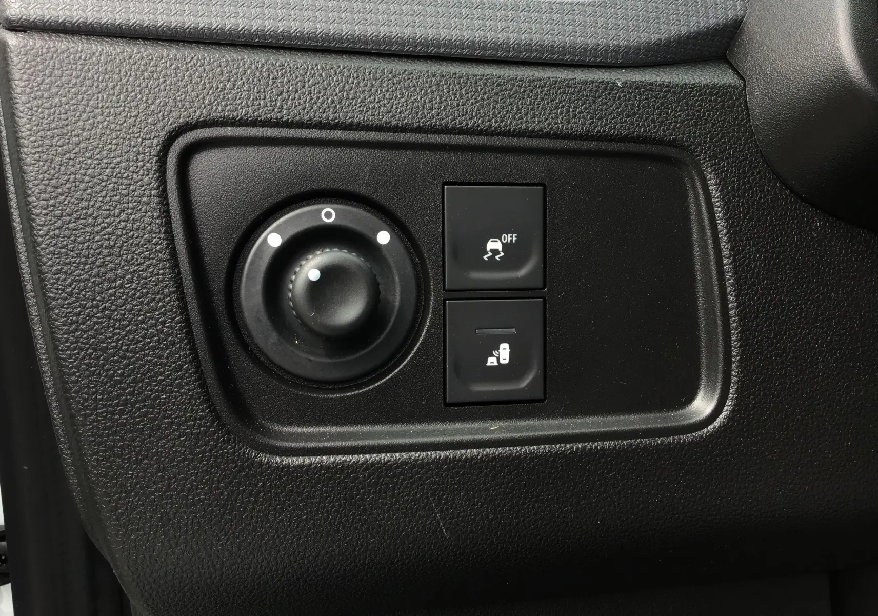 Gros plan sur les commandes noires de la planche de bord du Renault Express Van blanc 2024, avec réglage des rétroviseurs et contrôle de stabilité.