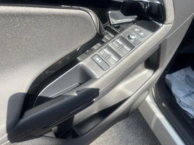Gros plan sur la porte avant gauche du Range Rover Evoque Indus Silver, montrant les commandes des vitres et le bouton de verrouillage.