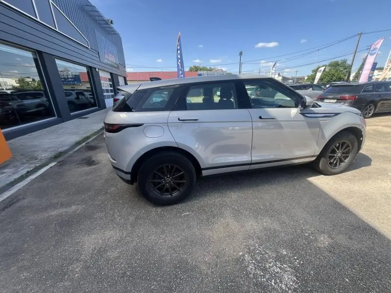 Range Rover Evoque Indus Silver vu de profil côté gauche, soulignant ses jantes noires et lignes modernes.