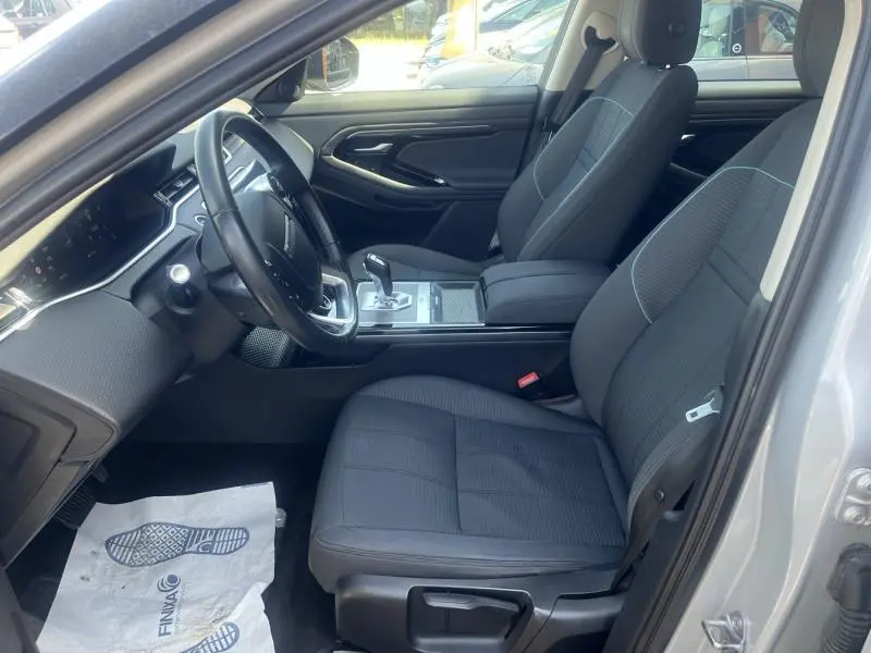 Intérieur avant du Range Rover Evoque 2019 en Indus Silver, sièges noirs et console centrale avec levier de vitesse automatique.