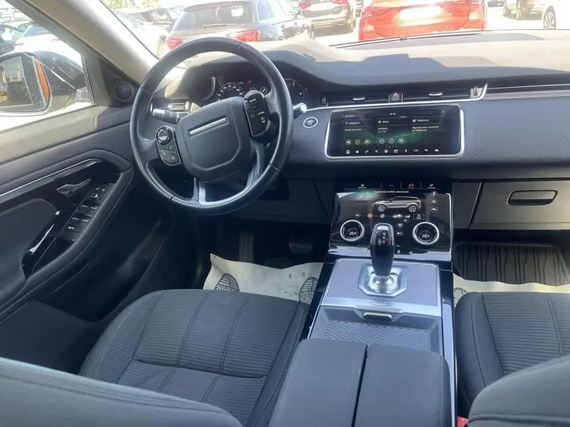 Intérieur du Range Rover Evoque 2019 vu côté conducteur, avec tableau de bord moderne et écran tactile central.