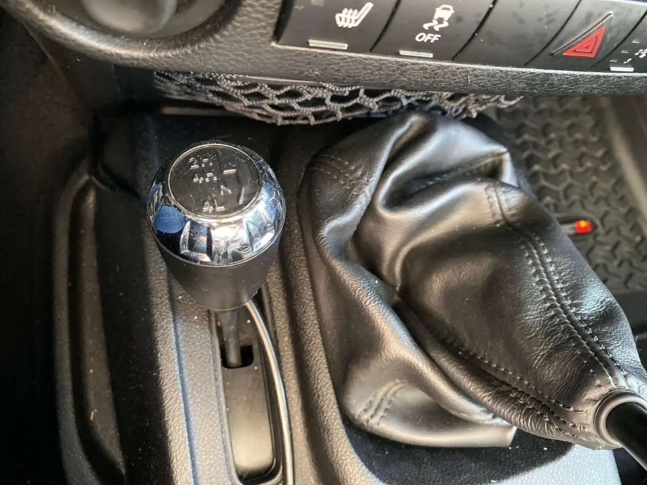 Gros plan sur le levier de vitesses manuel et la commande de boîte de transfert du Jeep Wrangler gris clair 2012.