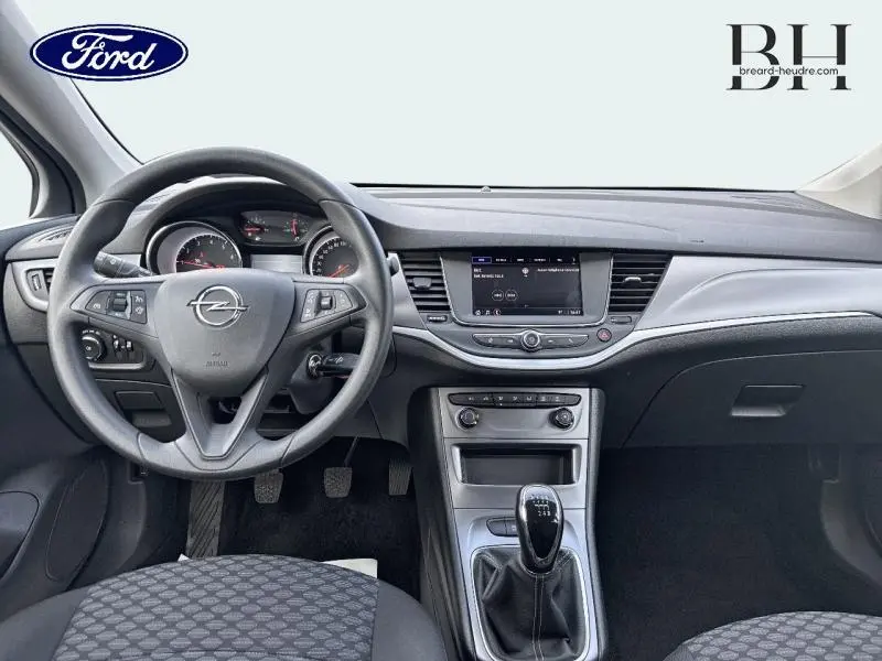 Vue intérieure avant de l'Opel Astra 1.2 Turbo 2020, tableau de bord gris avec volant multifonction et écran tactile central.