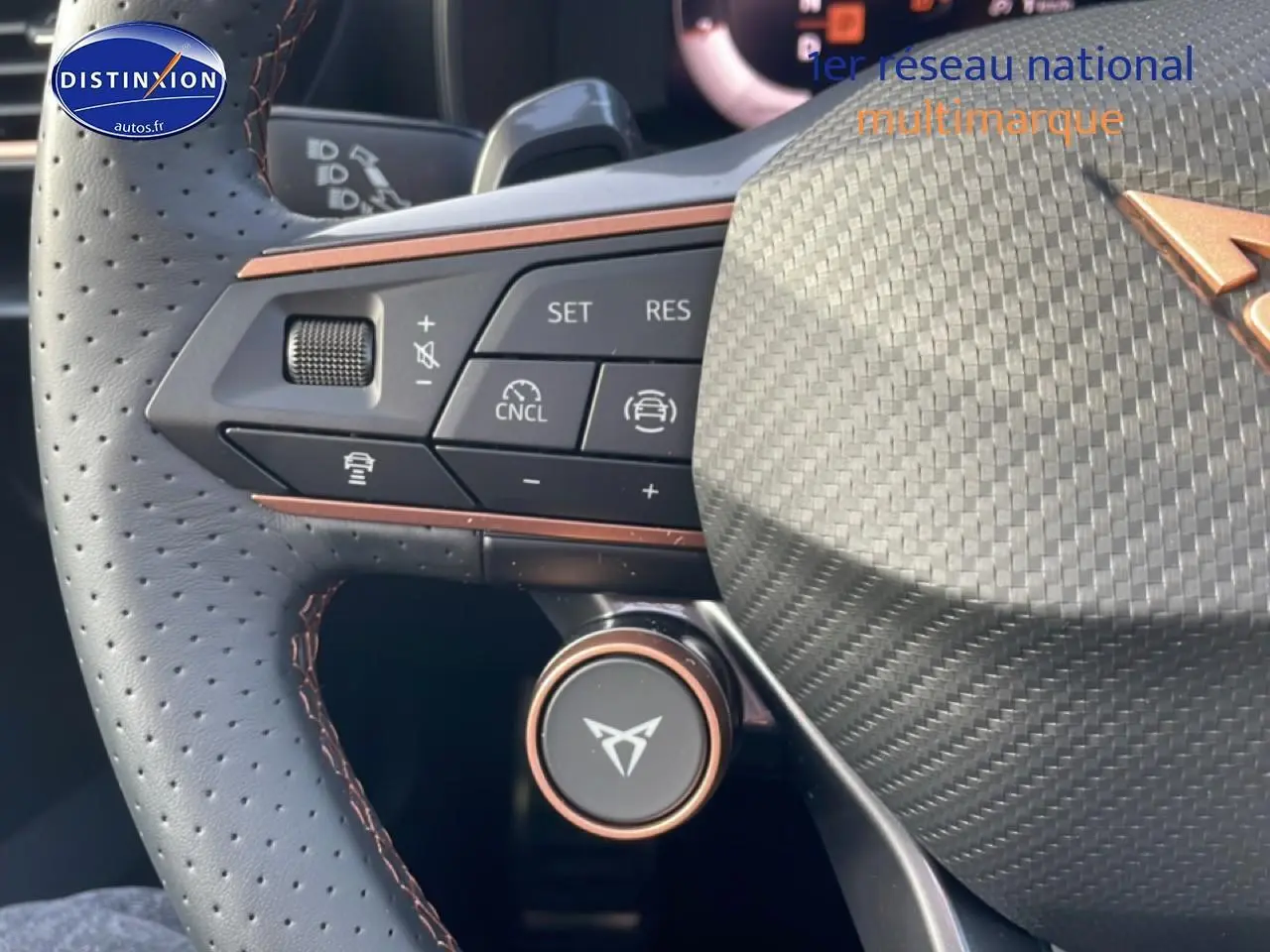 Gros plan sur le volant cuir perforé de la CUPRA Formentor avec commandes multifonctions et logo Cupra cuivré.