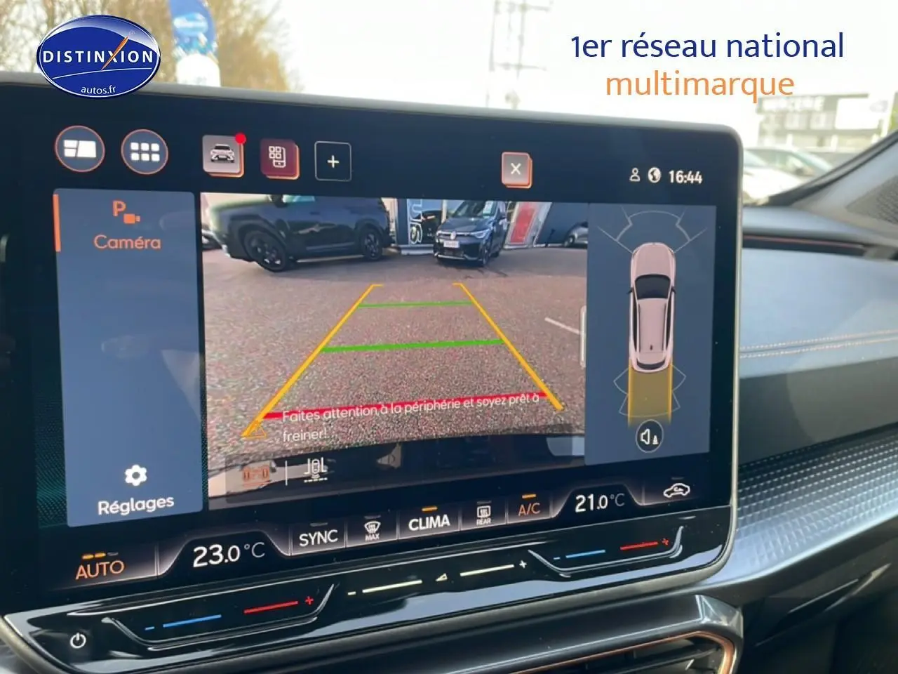 Écran tactile intérieur montrant la caméra de recul et l’aide au stationnement du CUPRA Formentor blanc Nevada.