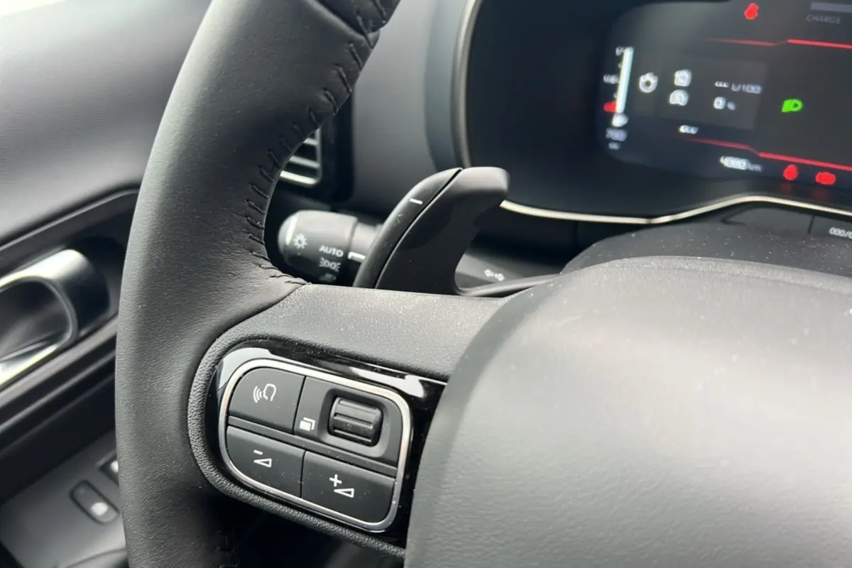 Gros plan sur le volant cuir multifonctions noir du Citroën C5 Aircross Hybrid 145, avec commandes au volant et palettes.