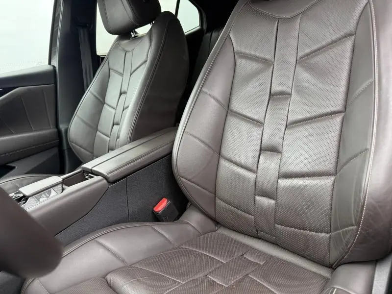 Gros plan sur les sièges avant en cuir marron du DS4 PureTech 130ch Opéra 2023, avec accoudoir central visible.