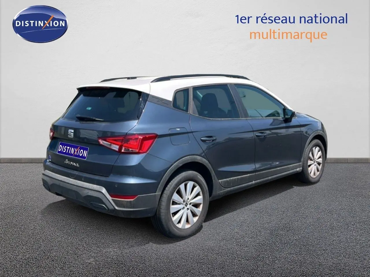 Vue 3/4 arrière droite d'une SEAT Arona gris magnetic avec toit blanc, mettant en valeur son design compact et moderne.
