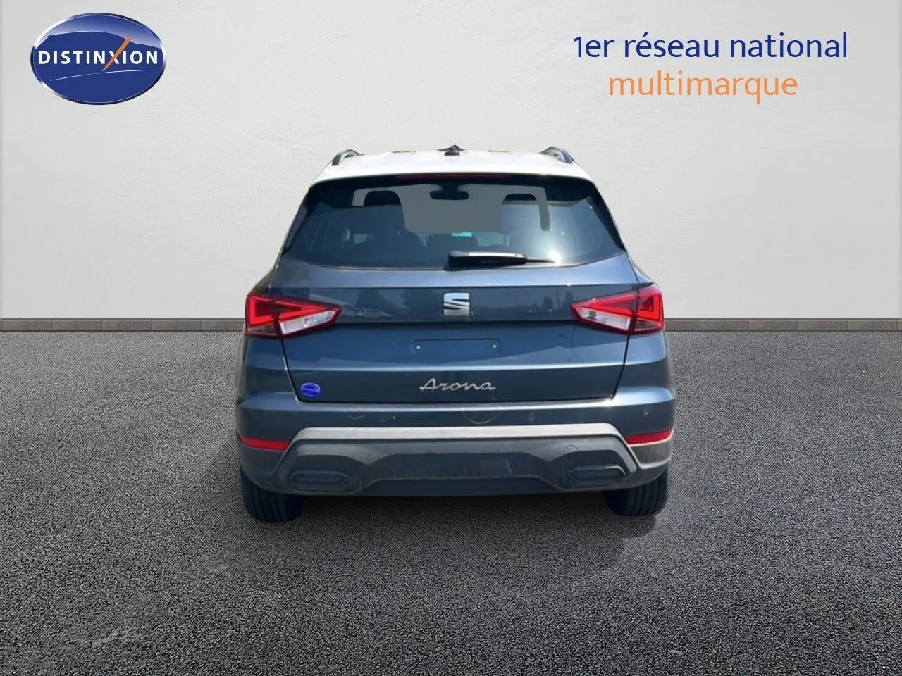 Vue arrière d'un SEAT Arona gris Magnetic avec toit blanc, mettant en valeur ses feux arrière anguleux et son design compact.