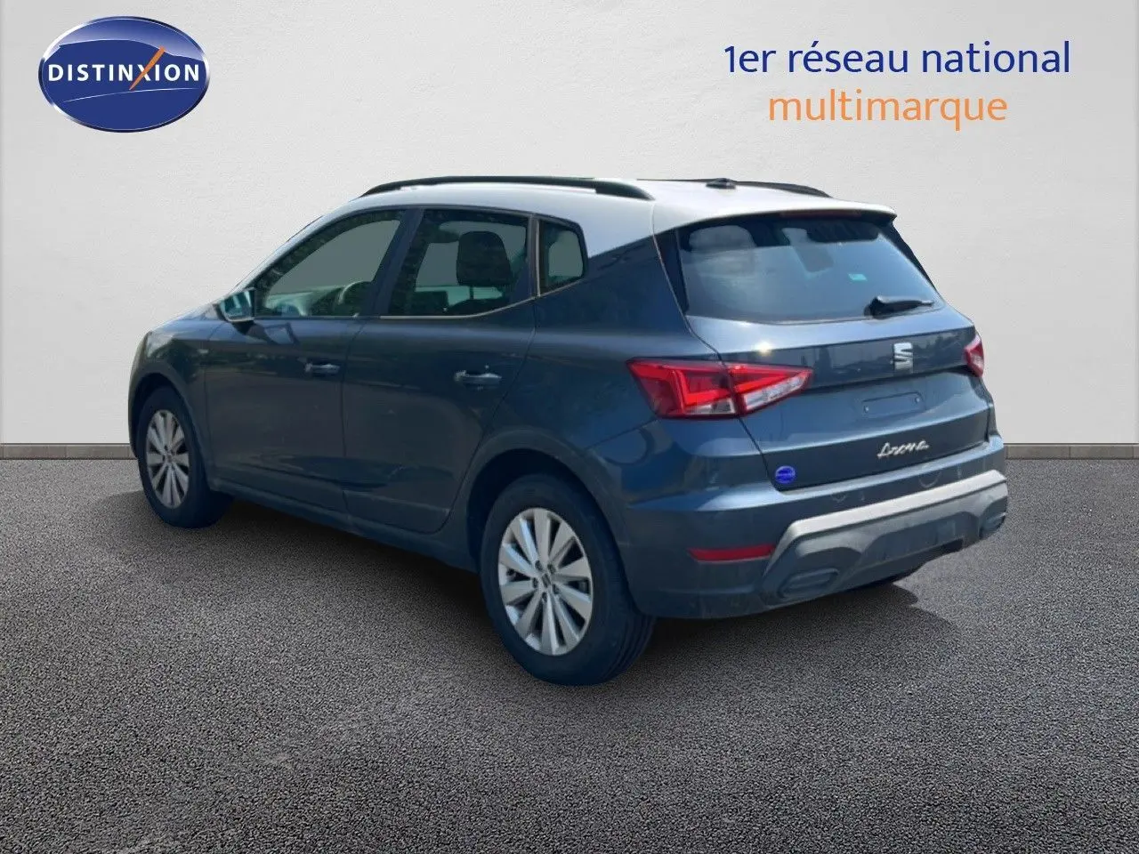 Vue 3/4 arrière droite d’un SEAT Arona gris foncé avec toit blanc, sur fond neutre en extérieur.