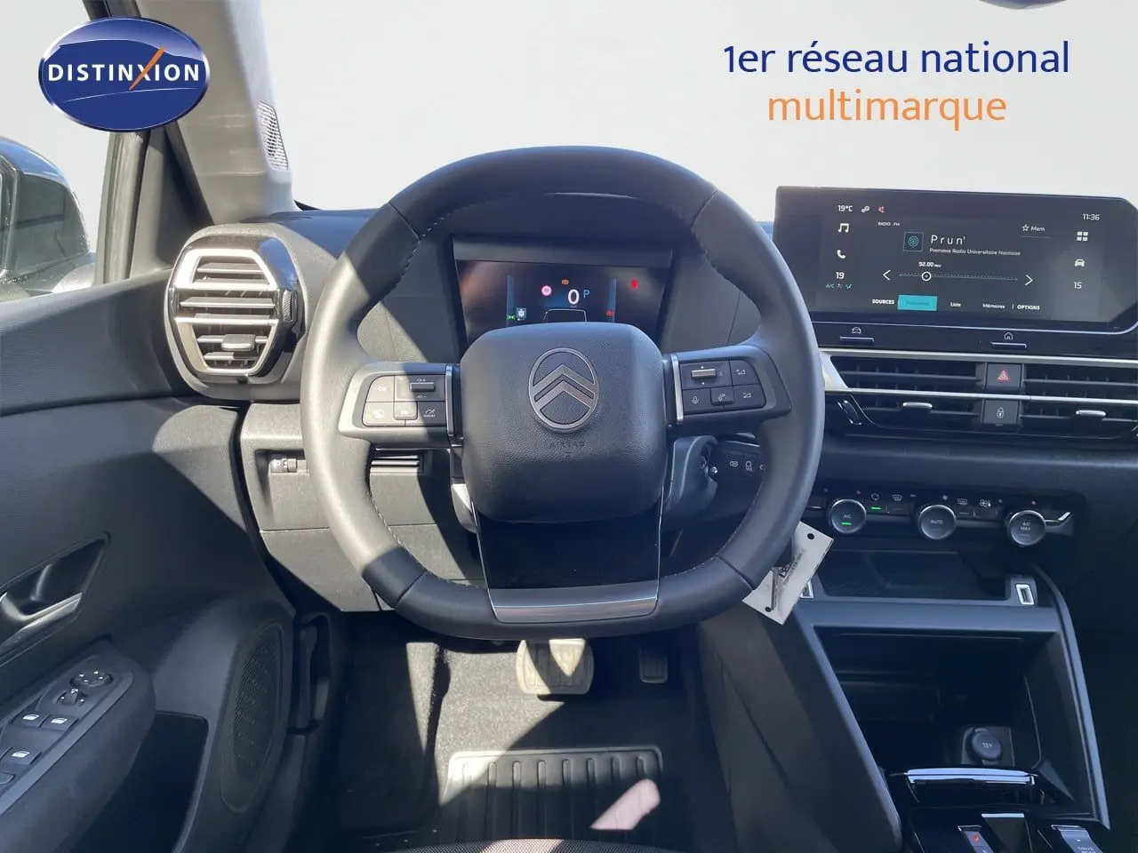 Vue intérieure centrée sur le volant Citroën C4 Hybrid 2026, tableau de bord numérique et écran tactile moderne.