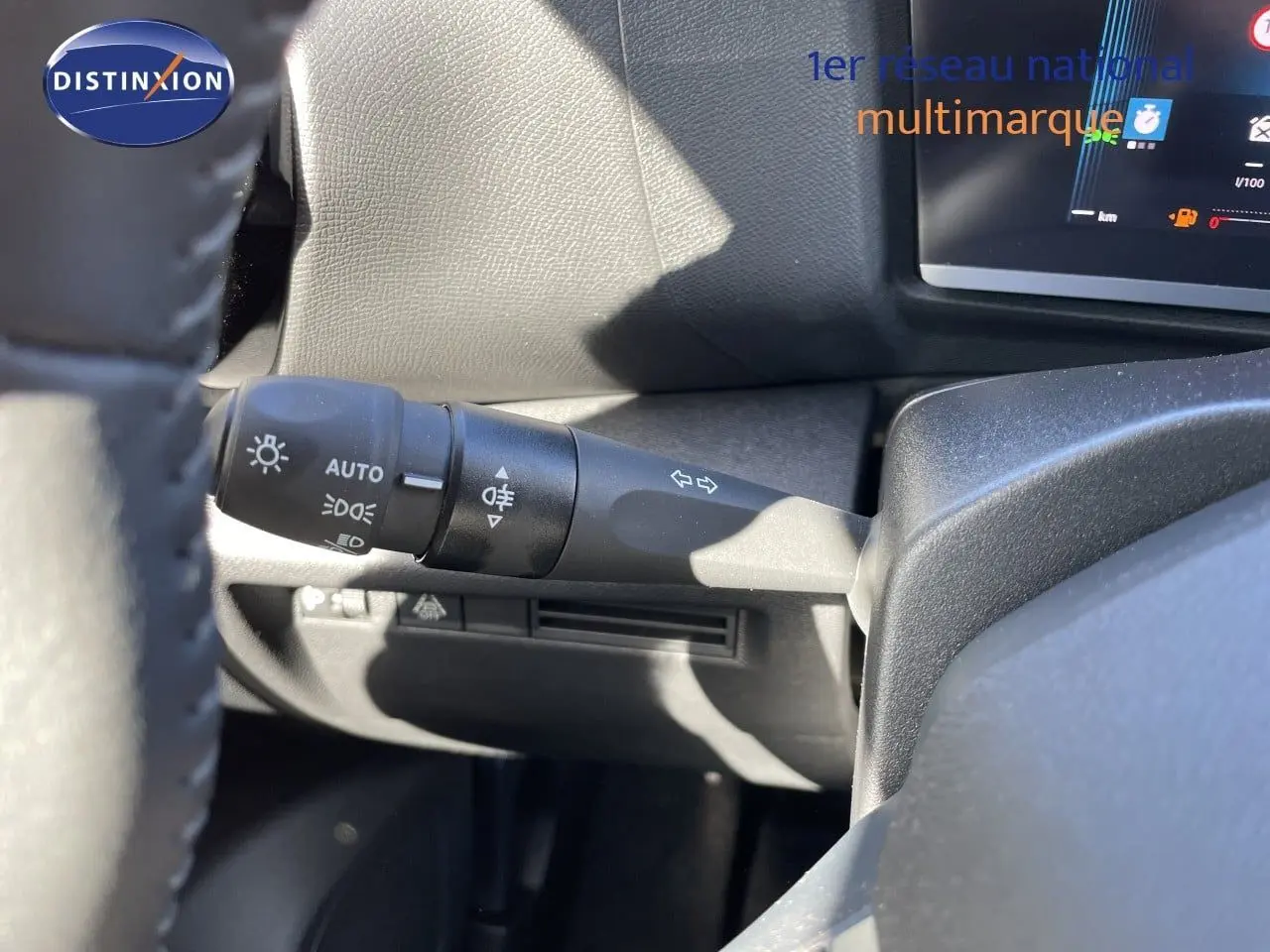 Gros plan sur la manette de commande des phares et clignotants à gauche du volant dans l’habitacle d’une Citroën C4 hybride.