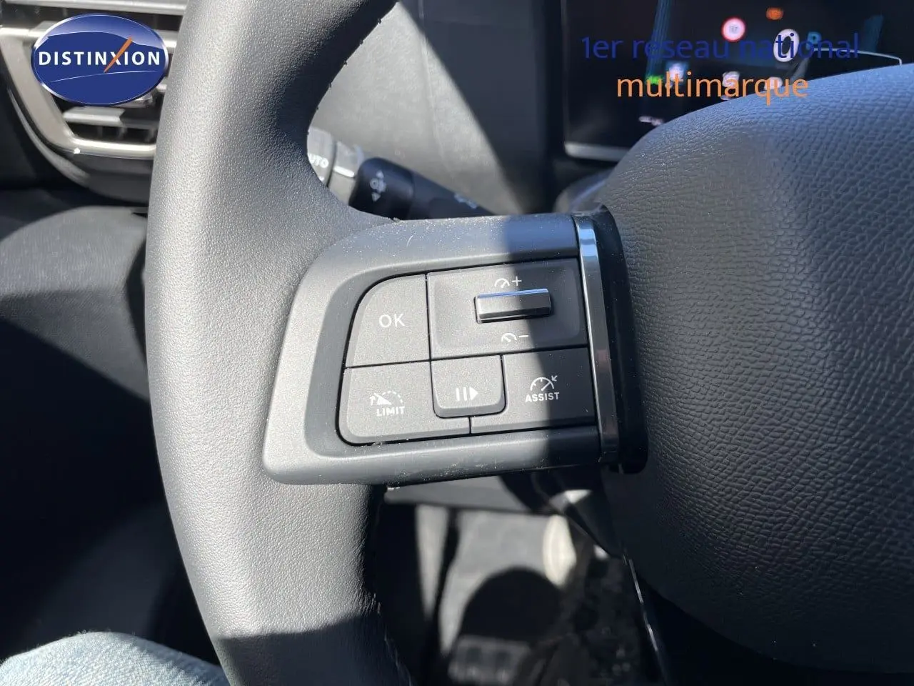 Gros plan sur les commandes de régulateur de vitesse au volant d'une Citroën C4 Hybrid 2026, intérieur noir.