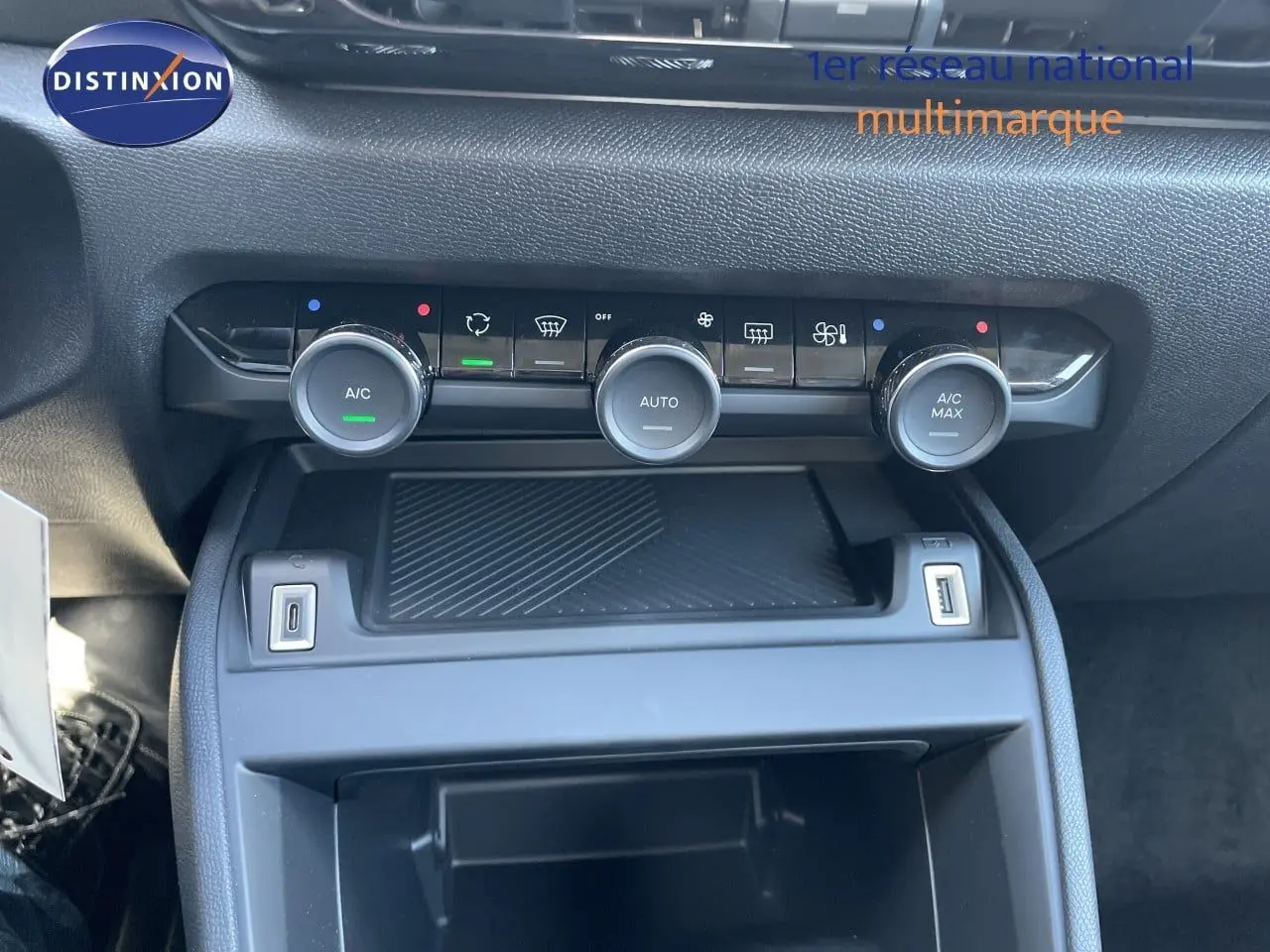 Vue rapprochée de la console centrale de la Citroën C4 Hybrid 145ch, avec commandes de climatisation et ports USB.