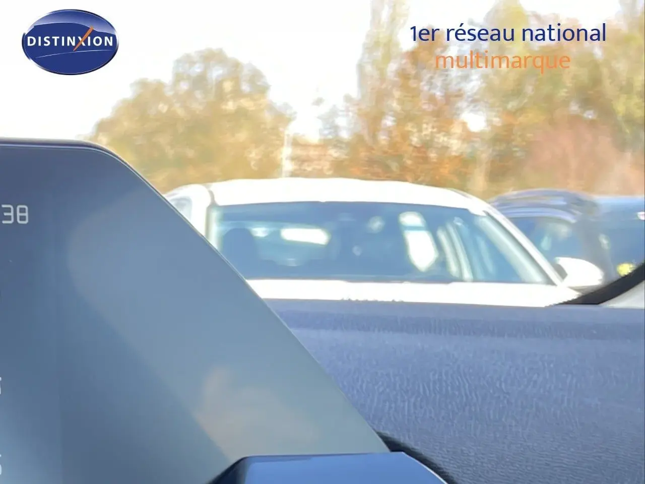 Vue intérieure depuis le tableau de bord d’une Citroën C4 Hybrid bleu eclipse métal, avec pare-brise et voitures en arrière-plan.