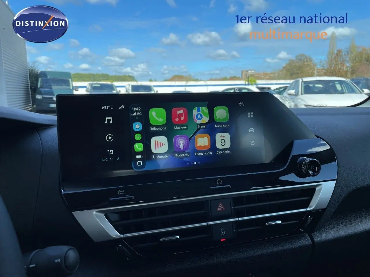 Écran tactile central affichant Apple CarPlay, tableau de bord noir intérieur d'une Citroën C4 hybride 2026.