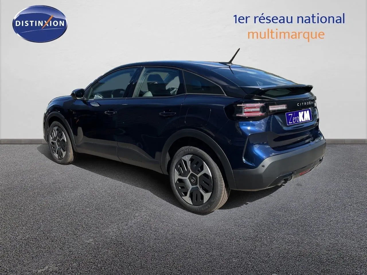 Vue 3/4 arrière droite d'une Citroën C4 Hybrid 145ch bleu eclipse métallisé avec jantes distinctives et toit noir.