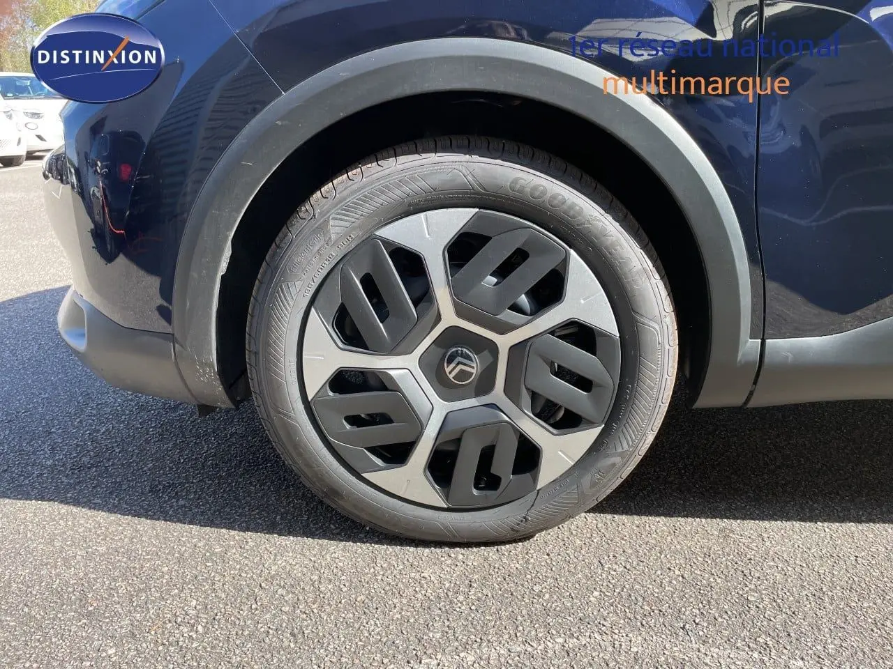 Gros plan sur la roue avant gauche d'une Citroën C4 bleu eclipse metal, mettant en valeur la jante au design moderne.