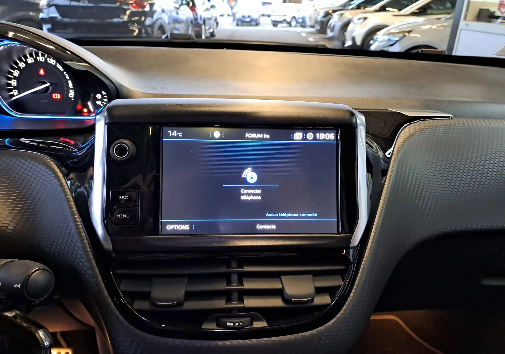 Vue rapprochée de l'écran tactile central et du tableau de bord noir d'un Peugeot 2008 gris 2019 en intérieur.