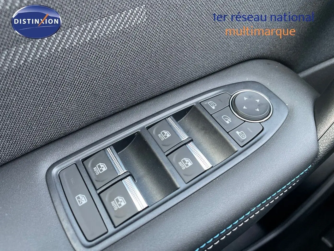 Gros plan sur les commandes électriques des vitres et rétroviseurs sur la porte côté gauche d'une Renault Symbioz gris rafale.