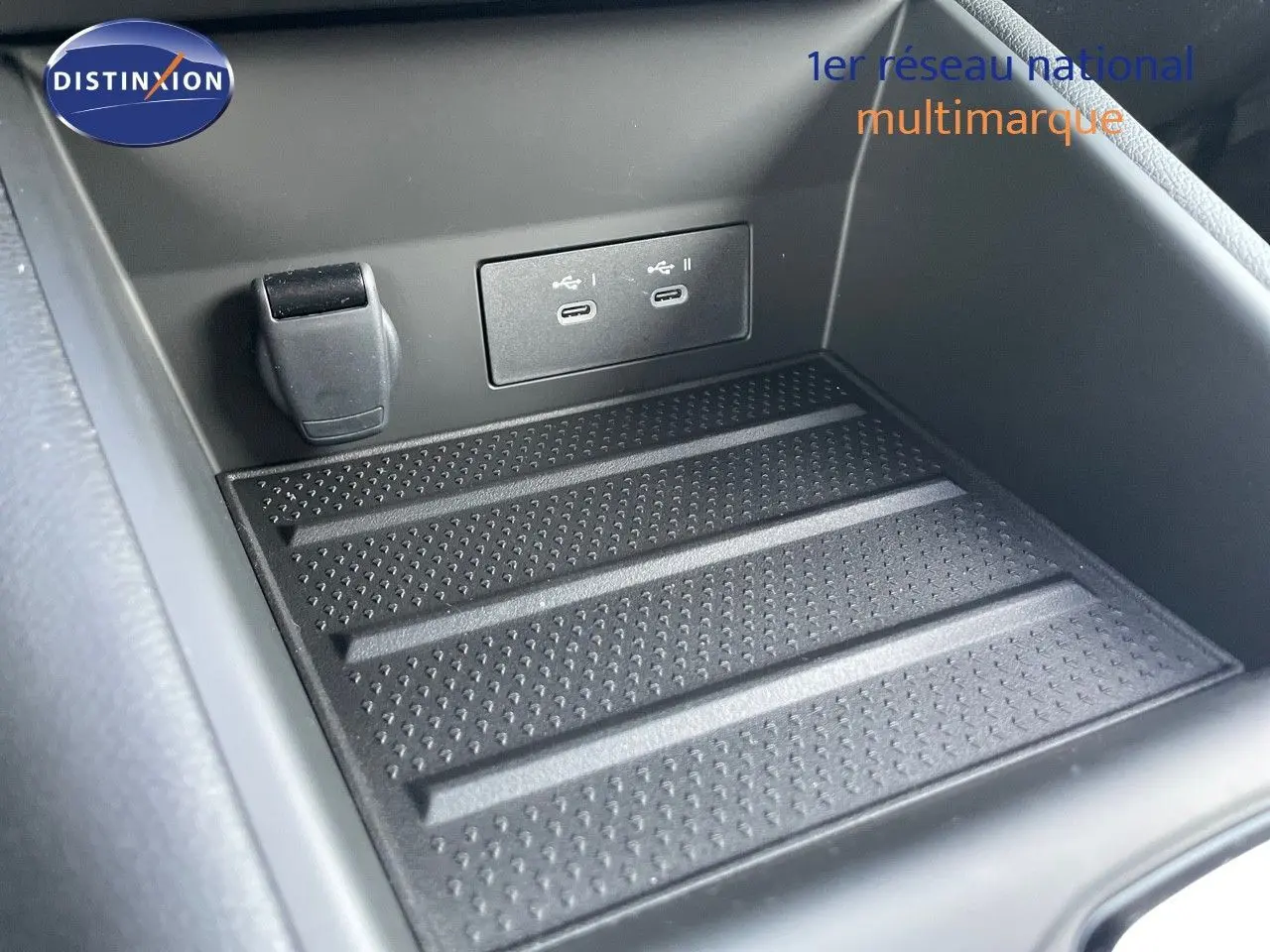 Gros plan sur la console centrale noire du Renault Symbioz 2024 avec deux ports USB-C et un chargeur 12V.