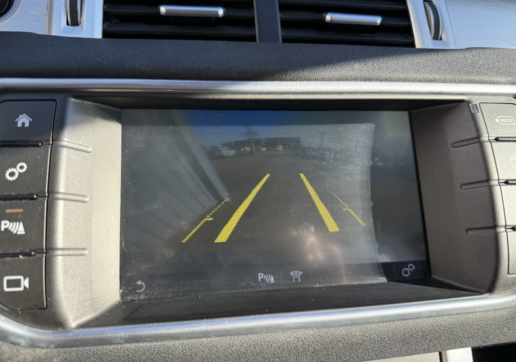 Écran central du Range Rover Evoque gris 2017 montrant la caméra de recul avec lignes de guidage jaunes.