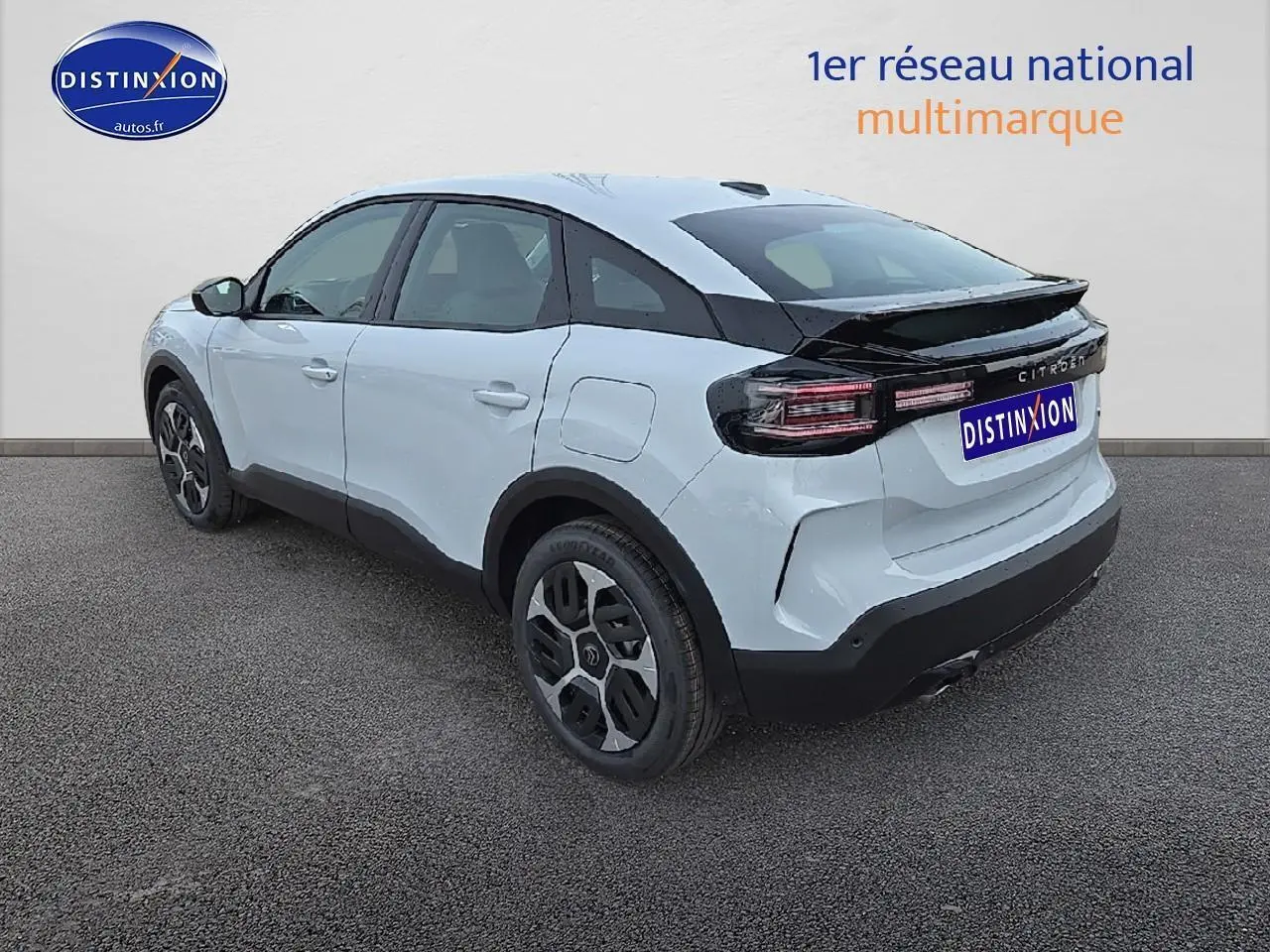 Vue 3/4 arrière droite d'une Citroën C4 blanche Okenite avec jantes 18 pouces et bande noire arrière brillante