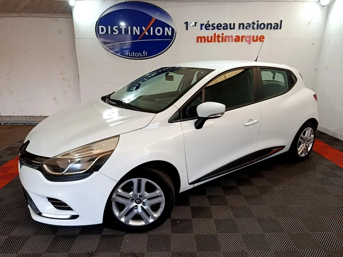 Renault Clio Zen Energy dCi 75 blanc vue 3/4 avant droit en intérieur avec jantes alliage et feux LED.