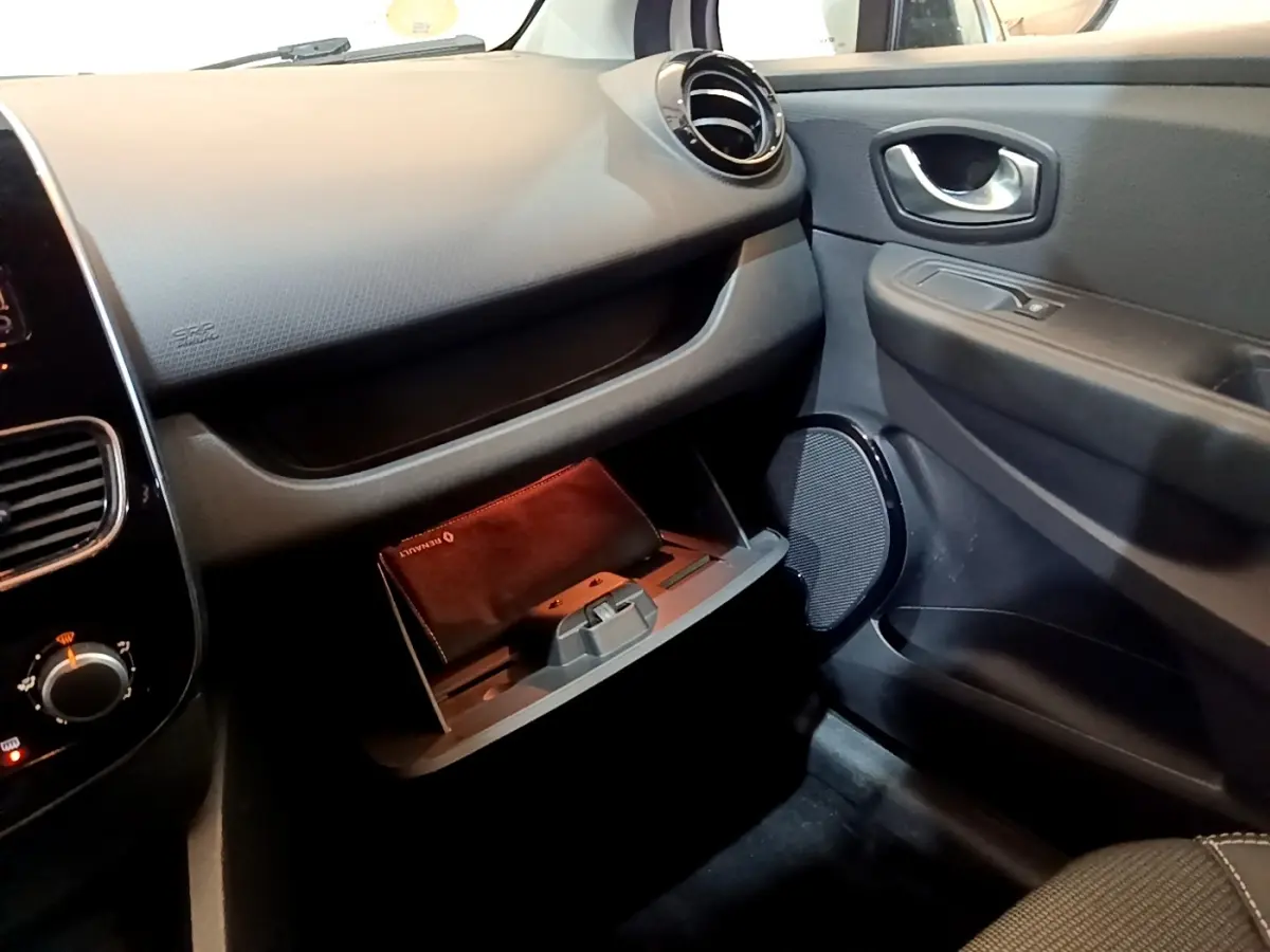 Intérieur côté passager de la Renault Clio Zen Energy dCi 75 2016, boîte à gants ouverte avec pochette Renault visible.