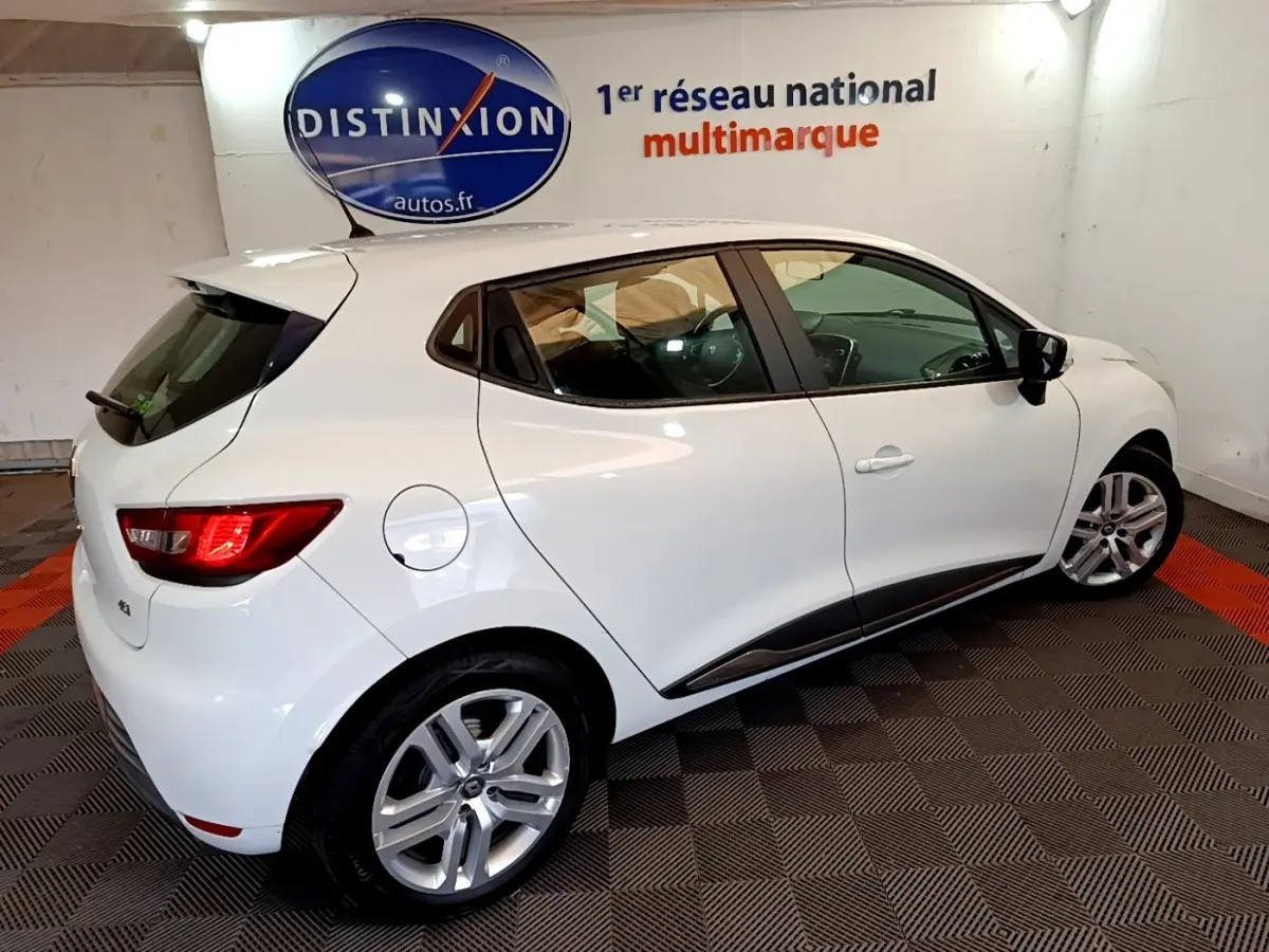 Vue 3/4 arrière droite d'une Renault Clio Zen Energy dCi 75 blanche, avec jantes alliage et rétroviseurs noirs.