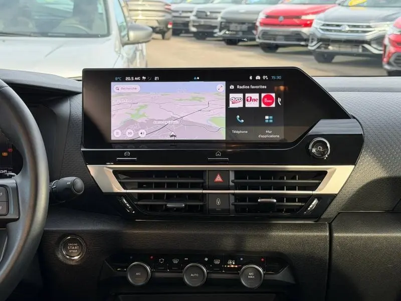 Vue intérieure du tableau de bord de la Citroën C4 X 2025, écran tactile central avec navigation et commandes climatisation.