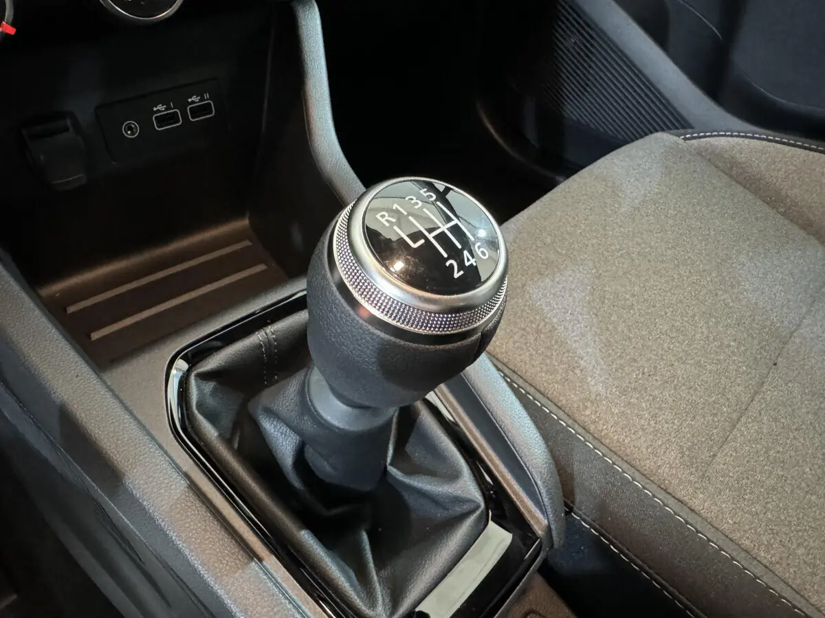 Le levier de vitesses manuel de la Renault Clio gris clair, vue rapprochée de la console centrale et siège passager.