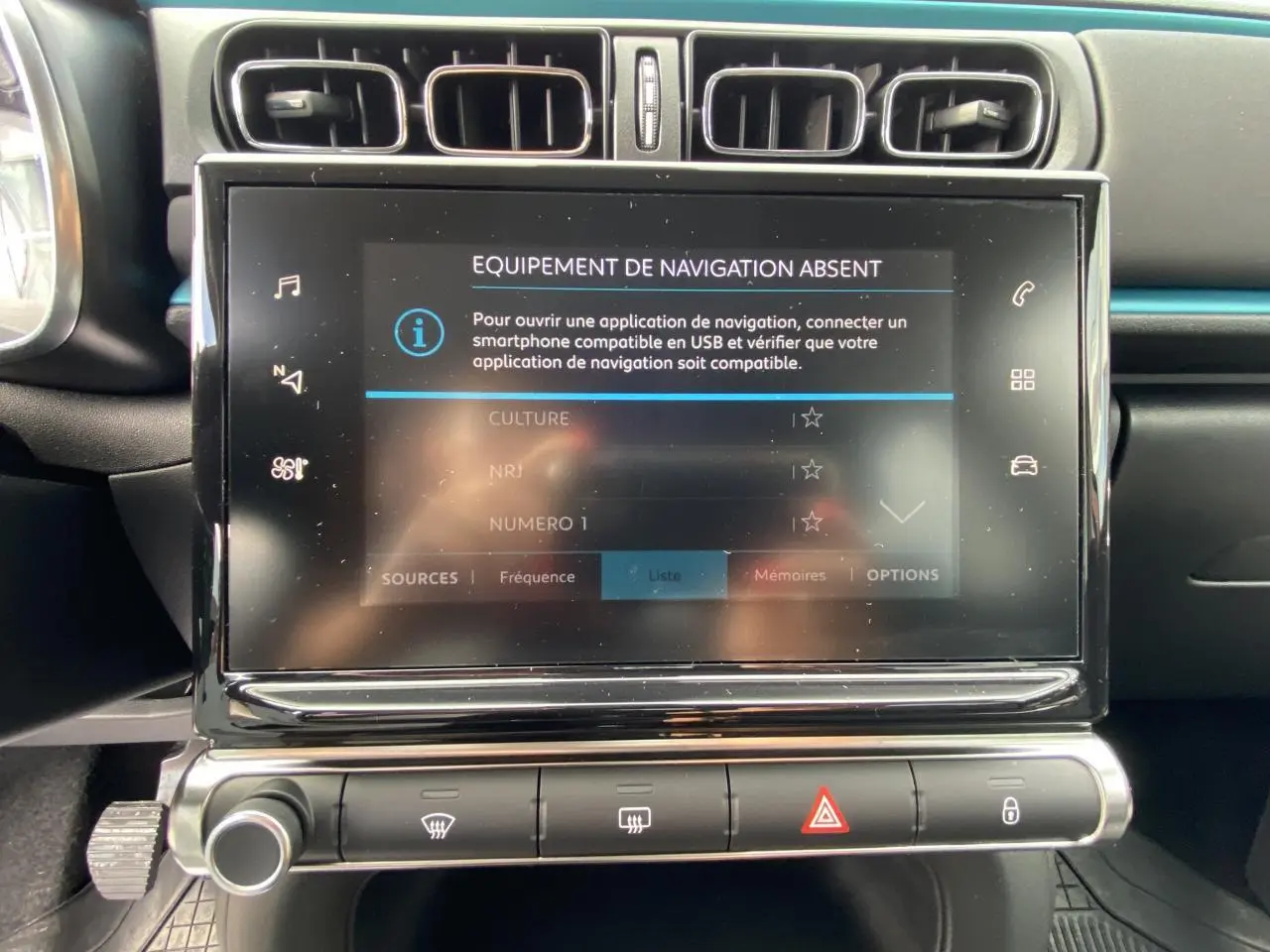 Écran tactile central en gros plan dans l'habitacle noir de la Citroën C3 2021, avec commandes climatisation visibles.
