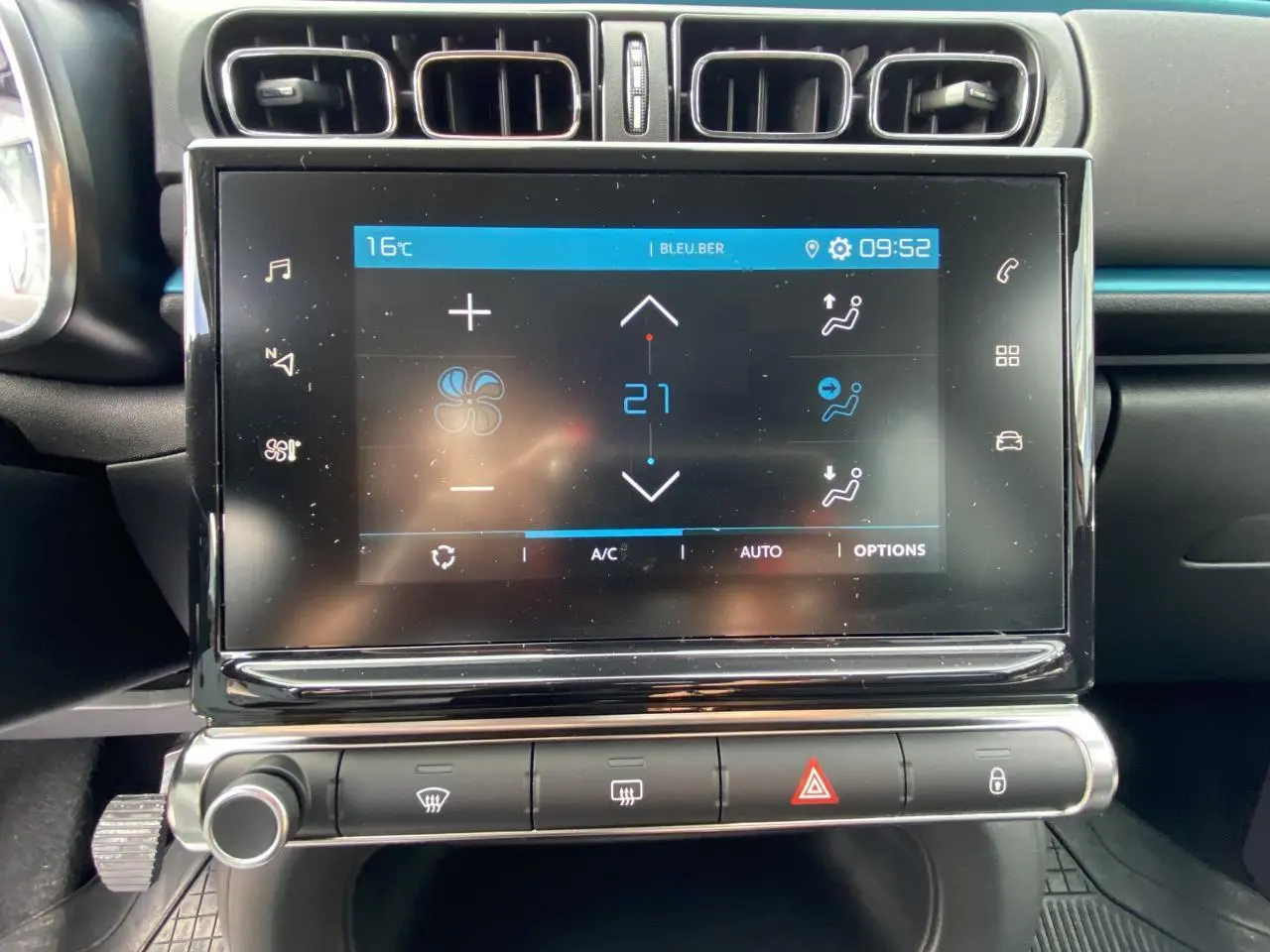 Écran tactile central du tableau de bord de la Citroën C3 noire, affichant les réglages de climatisation à 21°C.