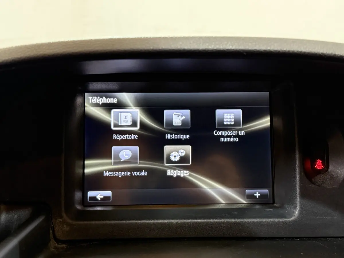 Écran tactile central du tableau de bord du Renault Kangoo blanc, affichant le menu téléphone avec plusieurs options.