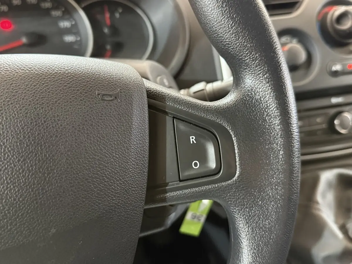 Gros plan sur le volant noir du Renault Kangoo 2021, avec boutons R et O visibles sur la partie droite.