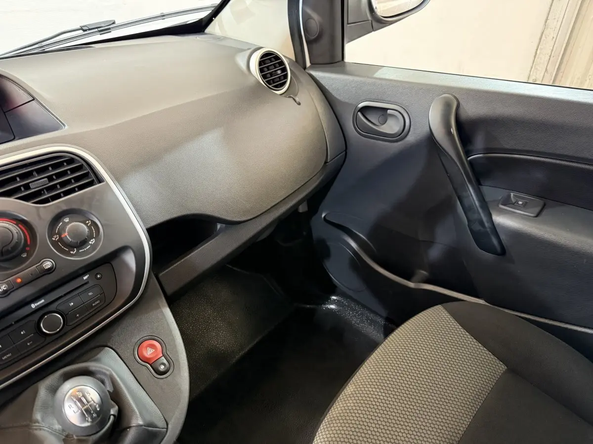 Vue intérieure côté passager du tableau de bord et porte noire du Renault Kangoo Extra R-Link 2021.