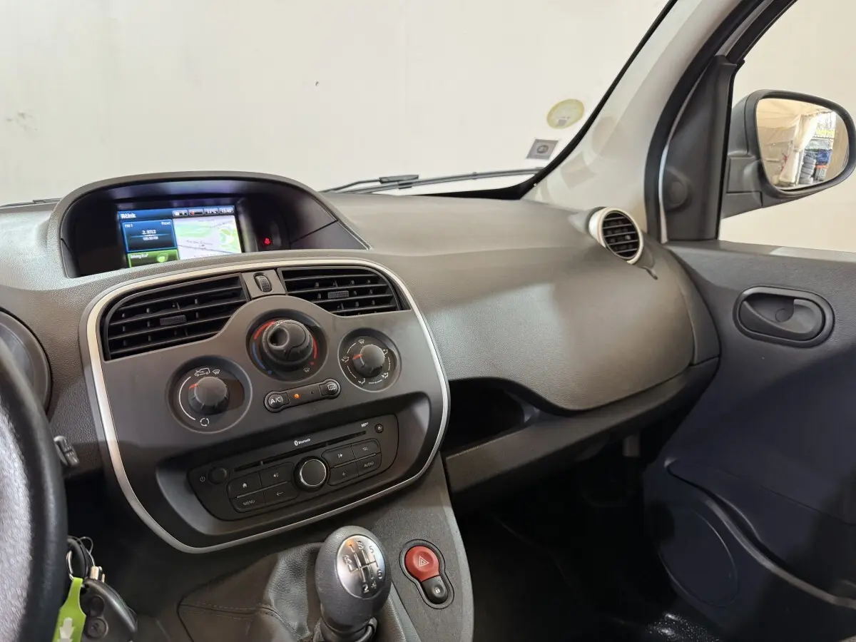 Intérieur du Renault Kangoo blanc 2021, vue côté passager sur tableau de bord avec écran tactile et levier de vitesse manuel.