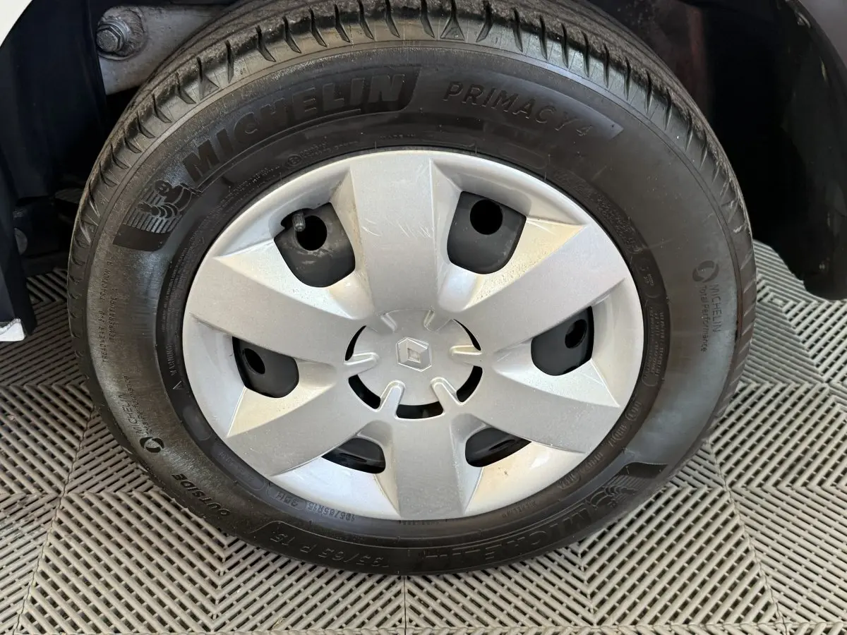 Gros plan sur la roue avant avec jante en acier et enjoliveur argenté du Renault Kangoo blanc 2021.