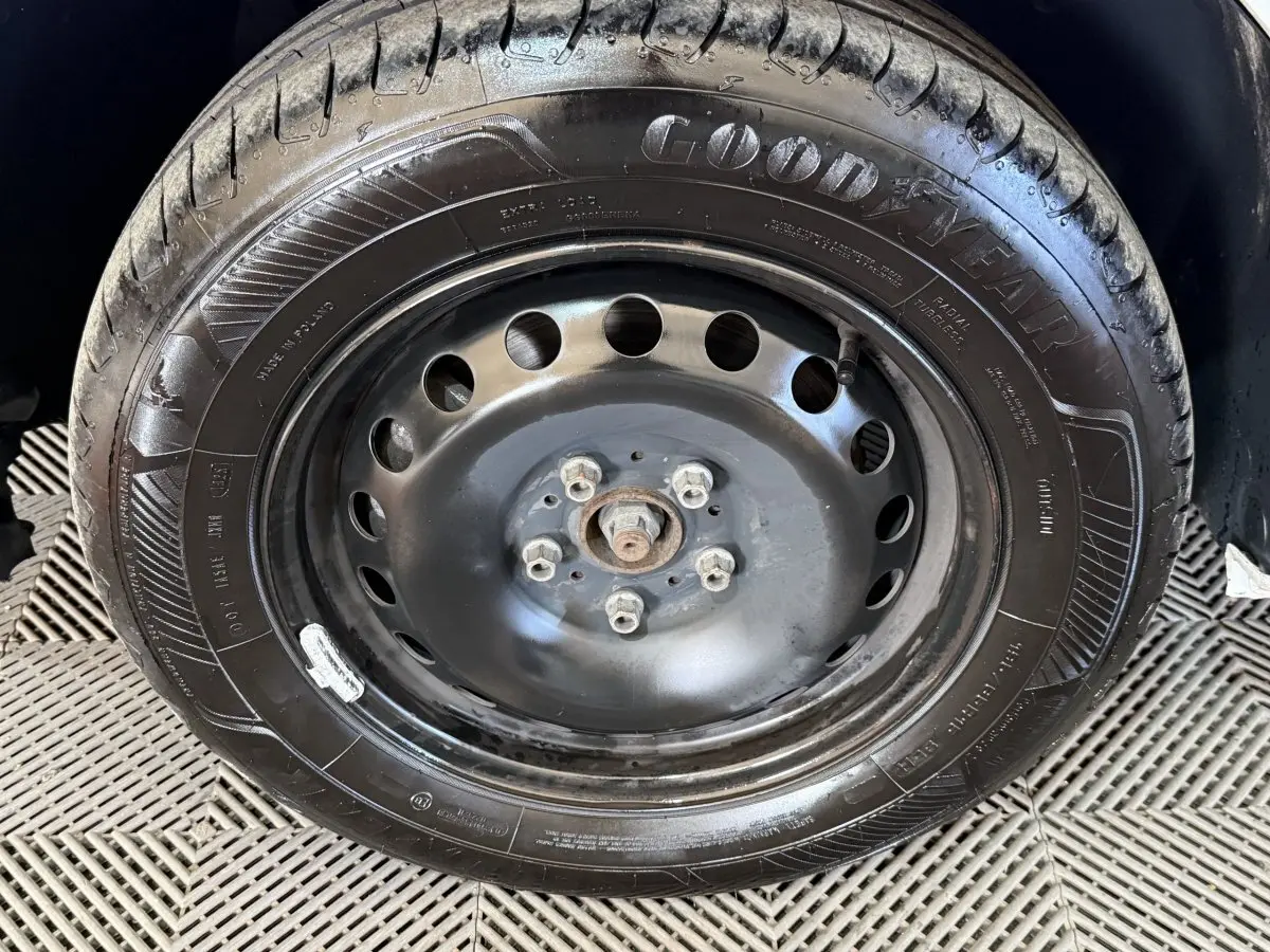 Gros plan sur la roue de secours noire en jante acier du Renault Kangoo blanc, vue de face.