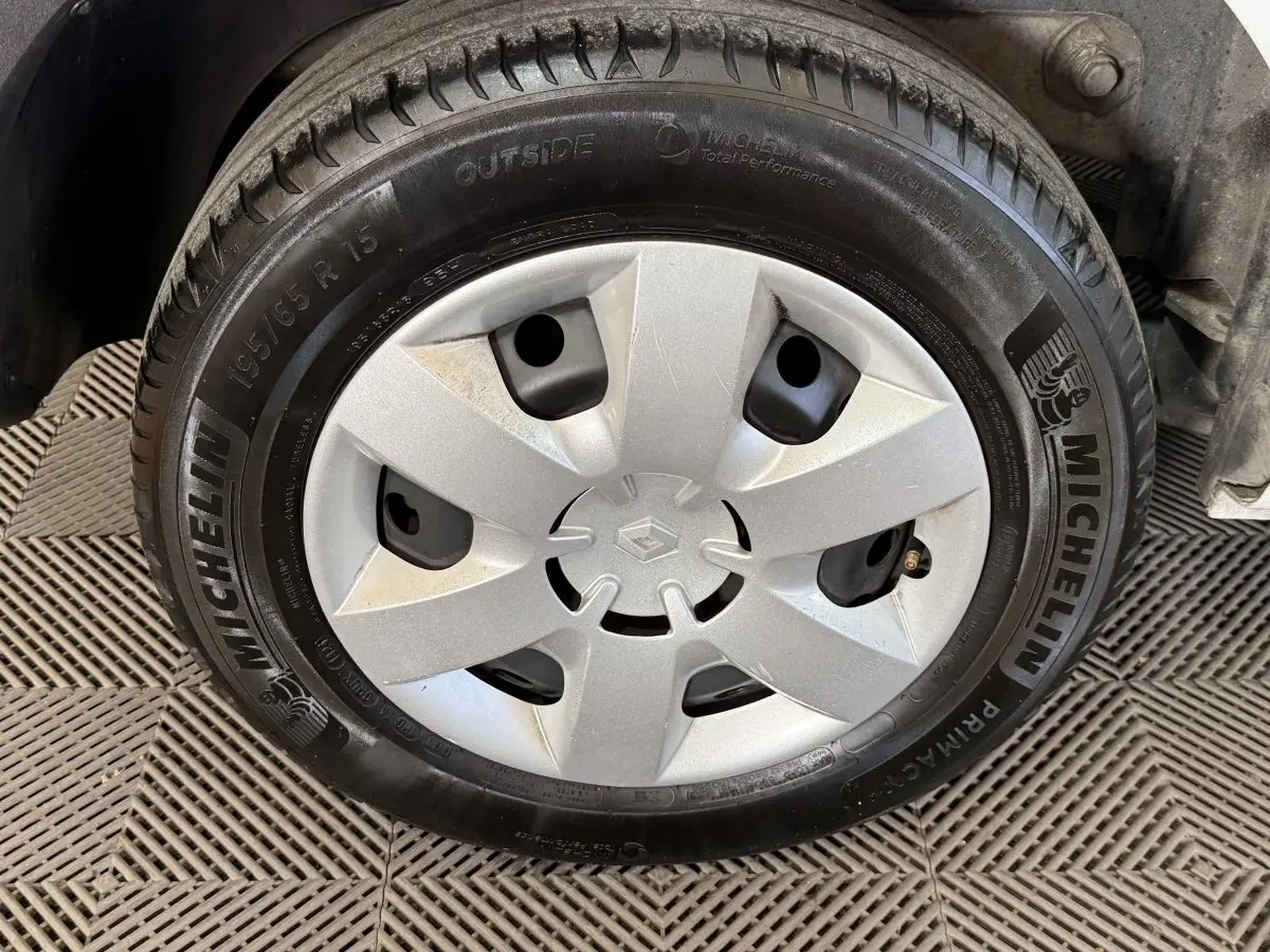 Gros plan sur la roue avant droite d’un Renault Kangoo blanc avec enjoliveur argenté et pneu Michelin.