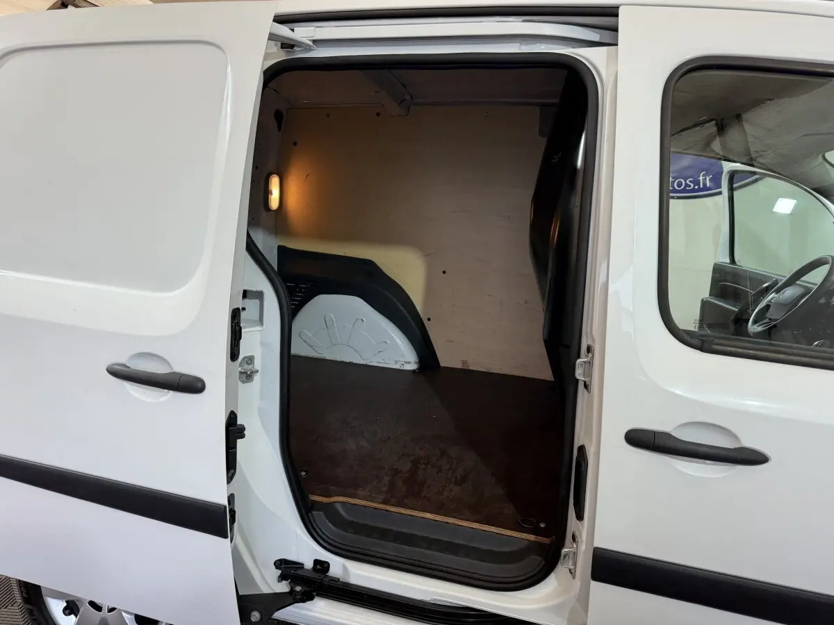 Vue latérale gauche du Renault Kangoo blanc 2021 avec porte coulissante ouverte montrant l’espace de chargement vide.