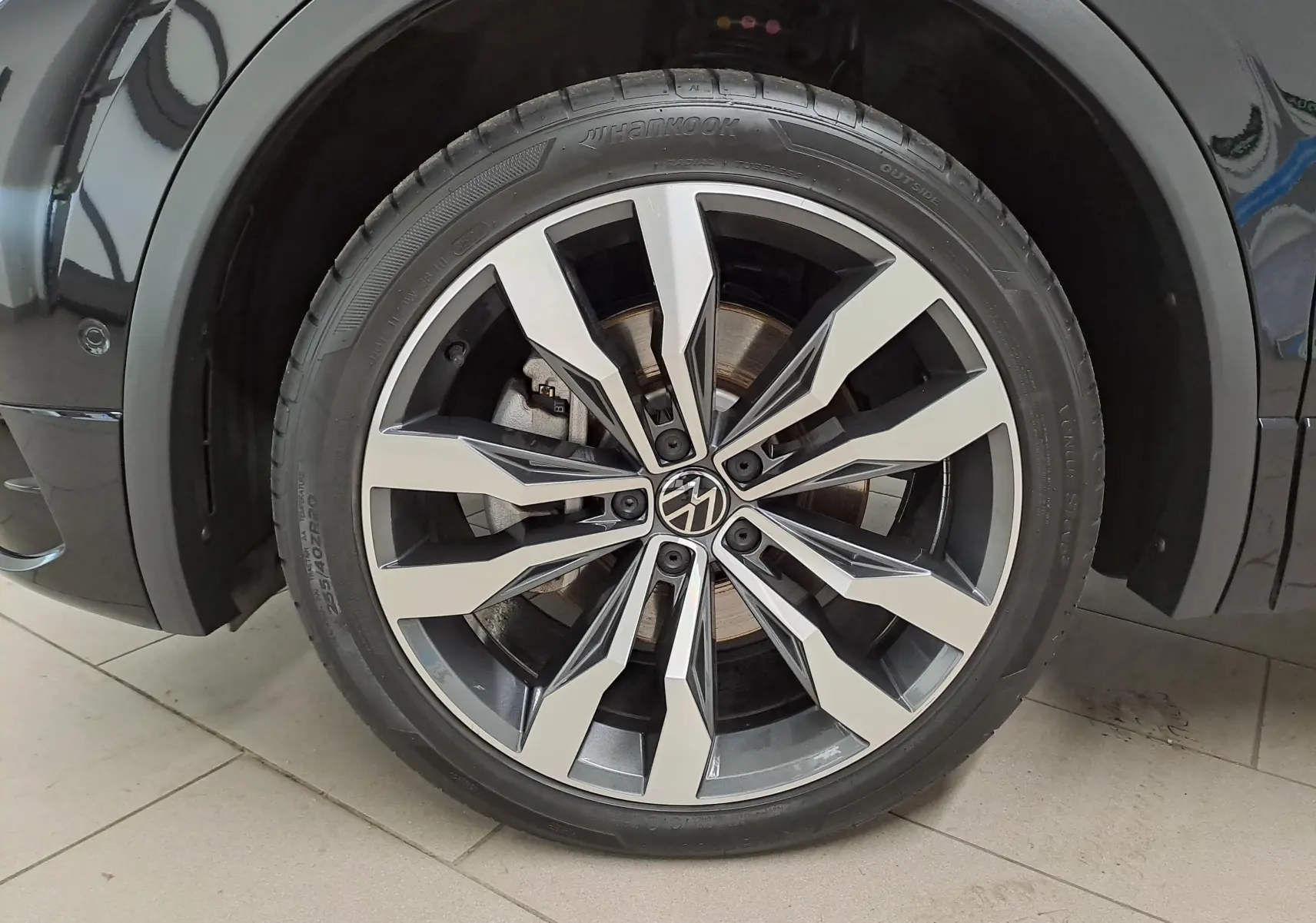 Gros plan sur la jante alliage 20'' Suzuka du côté avant droit du Volkswagen Tiguan Noir Intense nacré 2023.