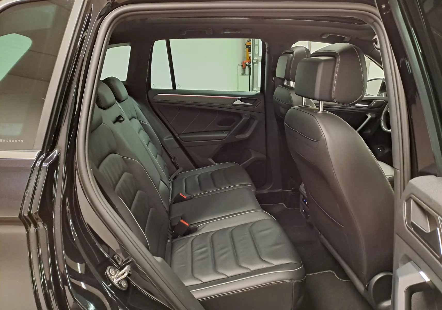 Vue intérieure côté gauche du Volkswagen Tiguan 1.4 eHybrid 2023, montrant les sièges arrière en cuir noir intense nacré.