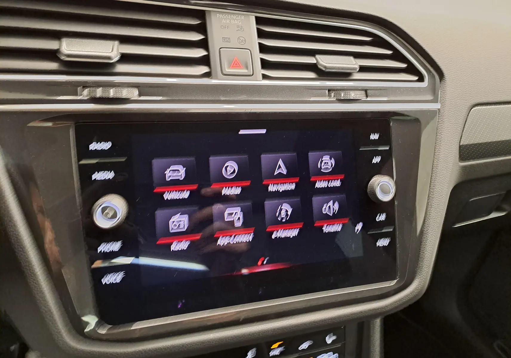 Gros plan sur l’écran tactile central du Volkswagen Tiguan 2023, affichant le menu multimédia et aides à la conduite.