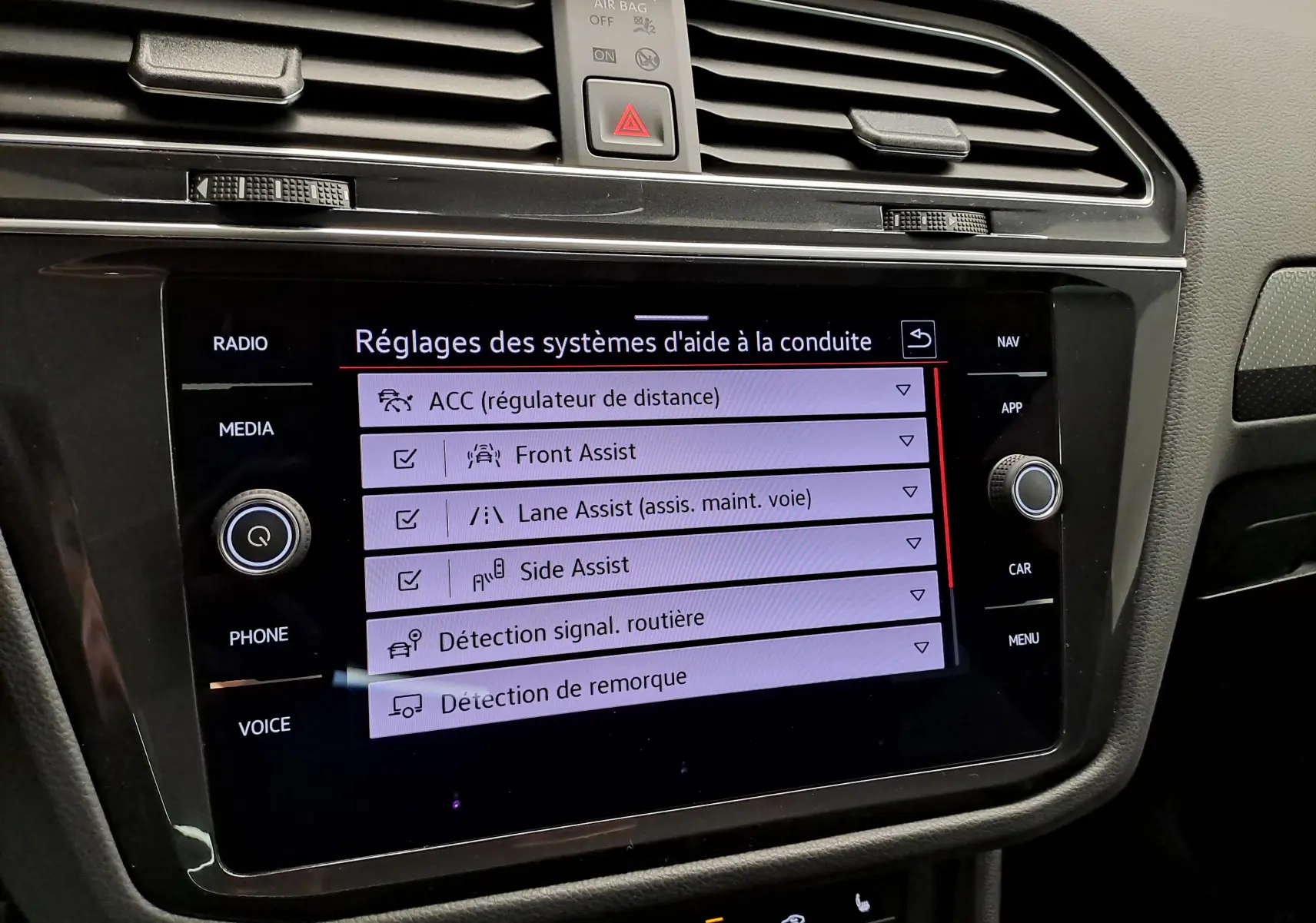 Écran tactile central du Volkswagen Tiguan 1.4 eHybrid 2023 affichant les réglages des aides à la conduite.