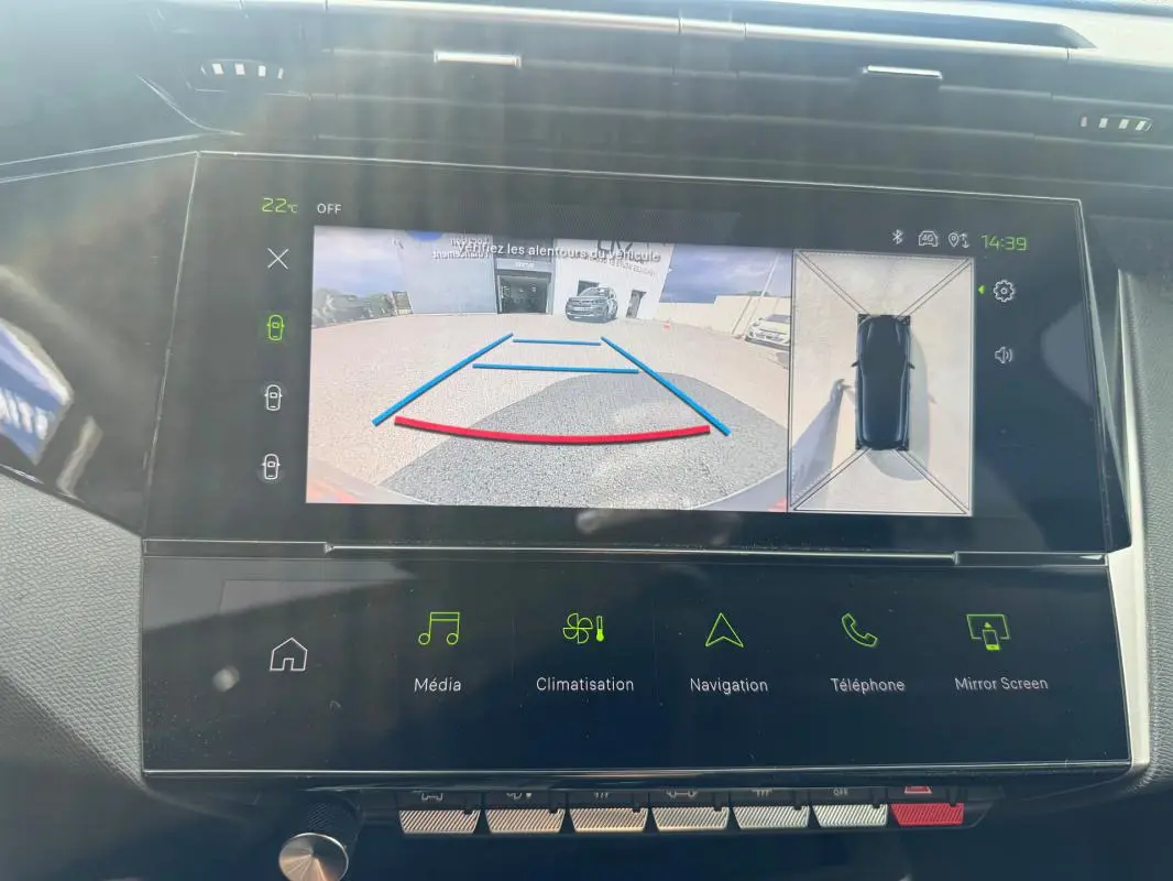 Vue rapprochée du tableau de bord de la Peugeot 308 Hybrid 2025 montrant l'écran de caméra de recul et les commandes tactiles.