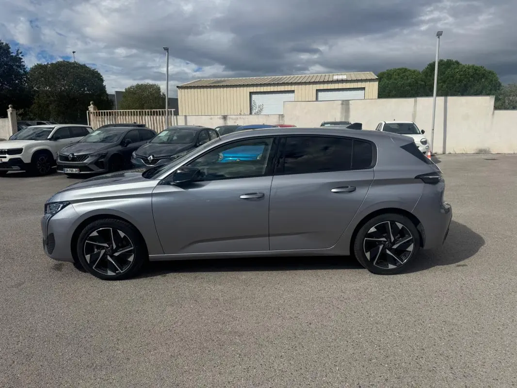 Peugeot 308 Hybrid gris vue de profil côté gauche, avec jantes alliage noires et vitres teintées.