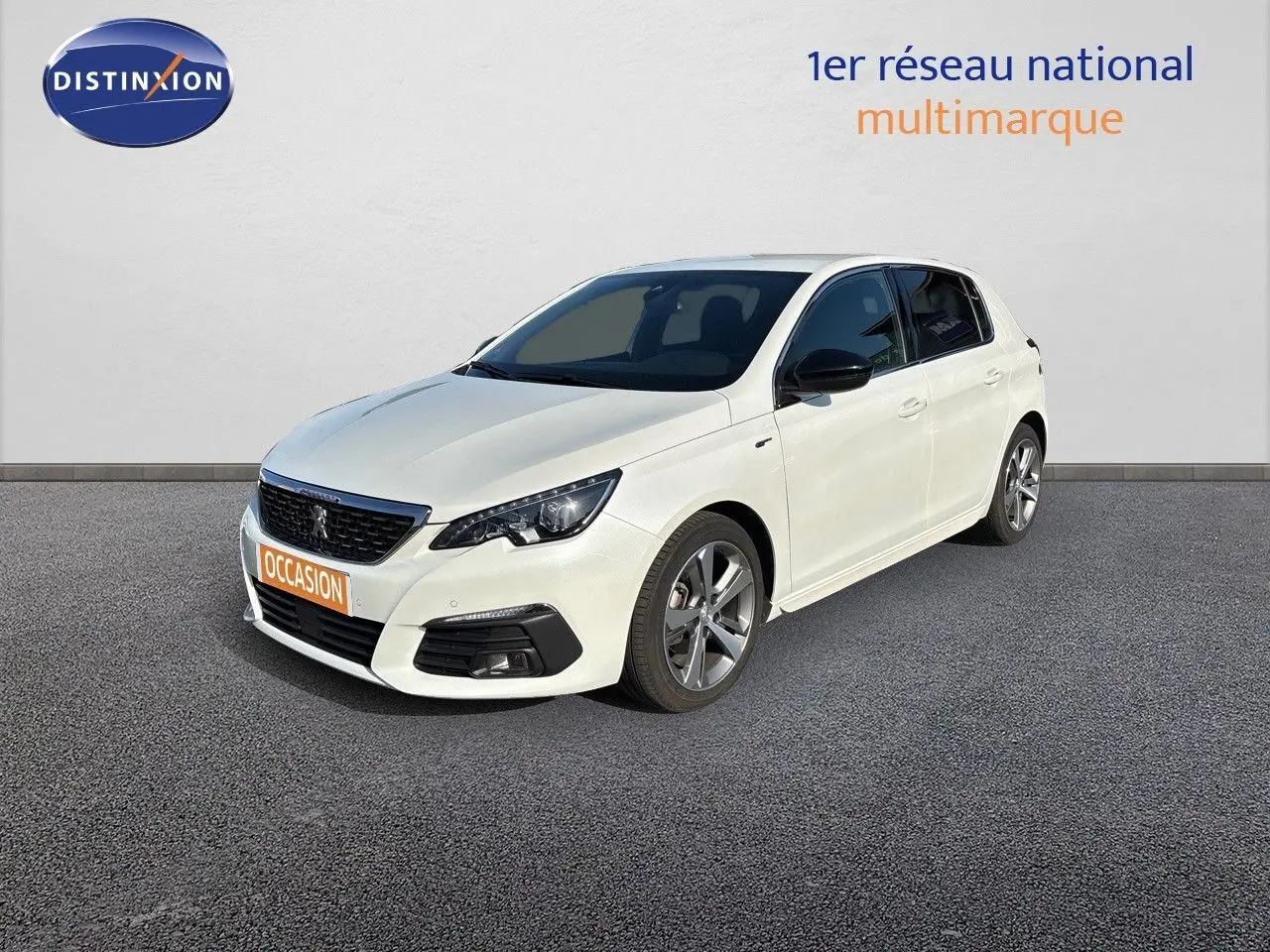 Peugeot 308 blanc nacré vue 3/4 avant droit, jantes alliage et calandre noire avec logo lion visible.