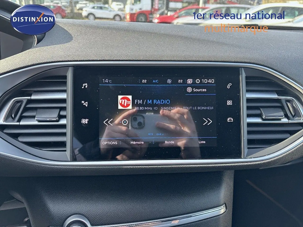 Écran tactile central du tableau de bord de la Peugeot 308 1.2 PureTech 130ch GT, affichant une radio FM.